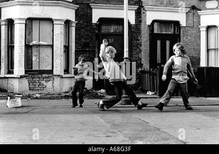 Jeunes garçons jouant au football dans la rue dans les années 1970 Banque D'Images