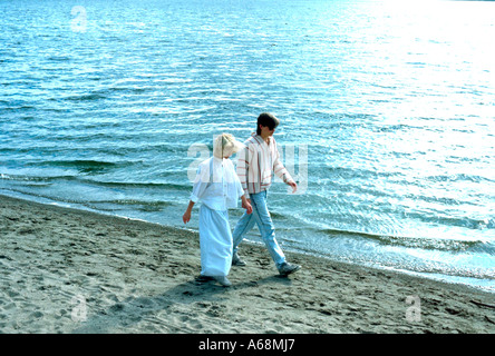 Couple de 21 ans marche main dans la main sur les sables du Lac Calhoun. Minneapolis Minnesota USA Banque D'Images