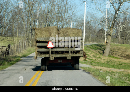 Vue arrière d'une charrette de foin d'être tiré vers le bas une route de campagne photographié dans la région de pâturin du Kentucky USA Banque D'Images