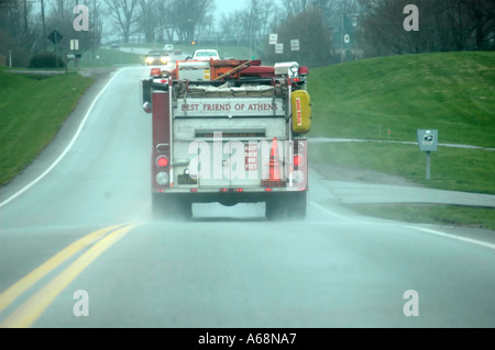 Vue arrière d'un camion rouge excès de pluie vers le bas une route dans l'lissés région du Kentucky Bluegrass USA Banque D'Images