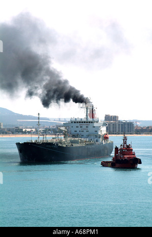 Retour émissions de fumée et de suie sortant de l'entonnoir Cargo navire polluant l'atmosphère locale et l'environnement arrivant au port de Palma Mallorca Espagne UE Banque D'Images