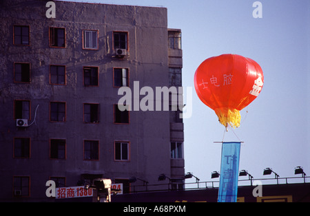Ballon à air chaud rouge volant à proximité d'un bâtiment. Beijing. La Chine. Banque D'Images