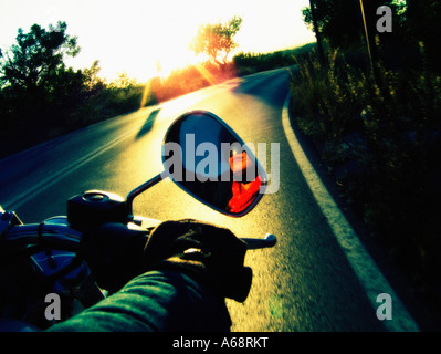 Circonscription d'une moto sous le coucher du soleil la lumière. Banque D'Images