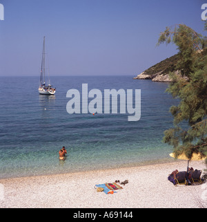 Couple dans la mer à plage de Makris Gialos & bay avec yacht à la location ou au large de l'île de Zakynthos les îles grecques Grèce Banque D'Images