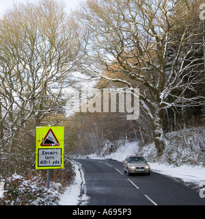 Voiture avec les phares sur les montées dans des conditions hivernales avec escape lane avertissement Wales UK Banque D'Images