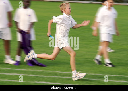 Sprint de garçon dans la course de relais de jour de sport d'école, Royaume-Uni Banque D'Images