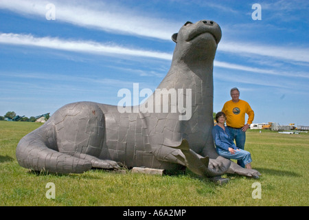 Couple posant avec une loutre statue. 'Otter Tail' Minnesota USA Banque D'Images