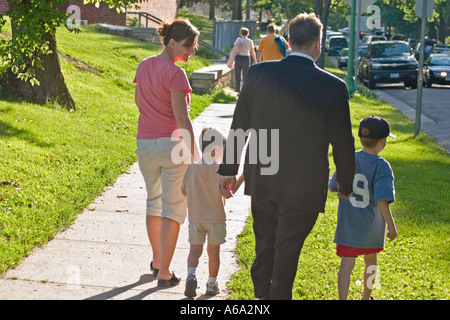 Laissant la famille T-ball jeu main dans la main. St Paul Minnesota USA Banque D'Images