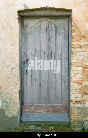 Un old weathered porte dans le cadre d'une ancienne église du 12ème siècle Banque D'Images
