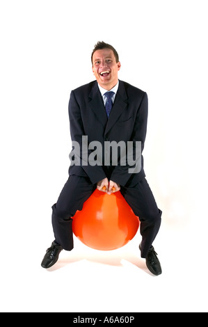 Businessman having fun sur un space hopper Banque D'Images