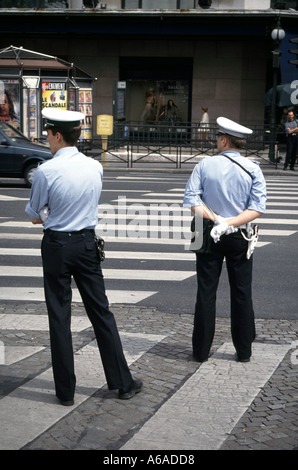 Paris scène de rue vue arrière police française en uniforme sur le service de la circulation au passage piéton marquage routier ensoleillé jour de printemps in1900 France Banque D'Images