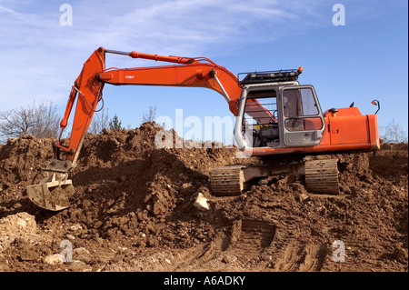 Digger Construction sur un monticule de terre Banque D'Images