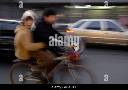 Un homme monte un vélo avec une dame passé à Beijing Chine 8 JAN 2006 Banque D'Images