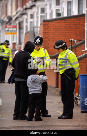 Un policier et une policière PARLER AUX RÉSIDENTS LOCAUX À BIRMINGHAM APRÈS UNE SÉRIE DE RAIDS LIÉES AU TERRORISME JAN 2007 Banque D'Images