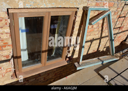 Remplacer les vieilles fenêtres en bois avec de nouvelles fenêtres à battants en bois SUR UNE MAISON EN RÉNOVATION UK Banque D'Images