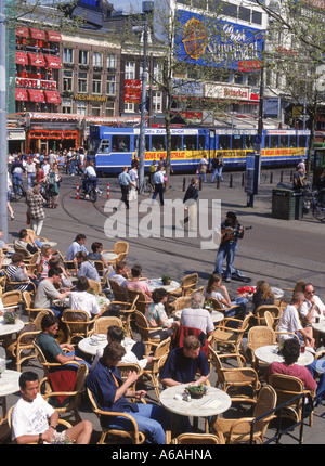 Les touristes l'été, des tramways, et des musiciens de rue à l'extérieur des restaurants trottoir sur Rembrandt Platz à Amsterdam Banque D'Images