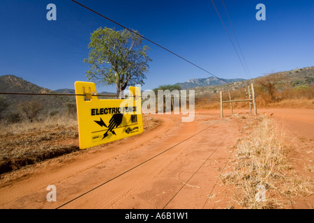 Panneau d'avertissement sur la clôture électrifiée au sanctuaire de rhinocéros noir Ngulia dans le parc national de Tsavo Ouest Kenya Afrique Banque D'Images