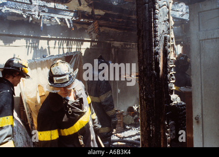 Incendie pompiers destruction maison résidentielle intérieur. Un pompier inspecte les dommages causés par un bâtiment brûlé. Pompier et restes charmés. New York, États-Unis Banque D'Images