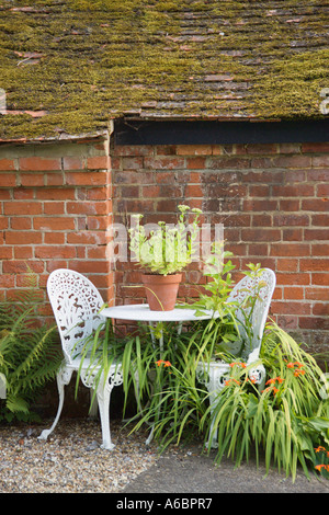 Table et chaises en fer forgé dans un jardin Banque D'Images