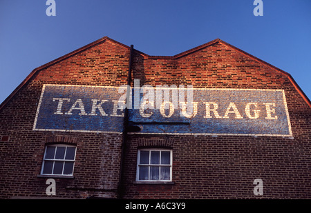 Prenez courage : vieille bière publicité peint sur forme de M Pignon de briques rouges, Southwark, Londres, Angleterre Banque D'Images