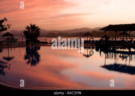 Rose lumineux ciel au-dessus de l'hôtel Barcelo El Castillo par le port à la tombée de la Caleta de Fuste Fuerteventura, Îles Canaries Banque D'Images