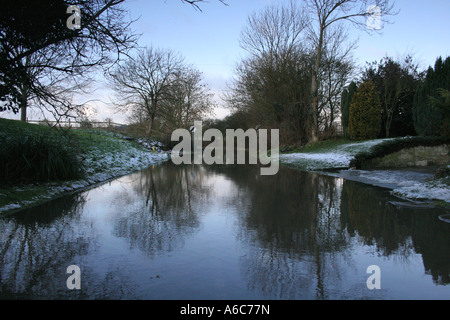 Route inondée en hiver avec la réflexion et de signalisation. Paysage. Stevington, Bedfordshire, Royaume-Uni. Banque D'Images