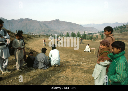 La vallée de Swat au Pakistan Mingora Bazar jeunes hommes jouer au cricket dans Hills Banque D'Images