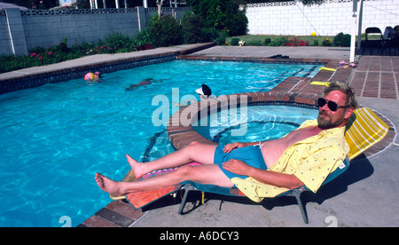 Propriétaire appréciant sa piscine à l'arrière-cour CA Banque D'Images