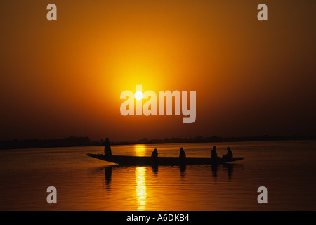 Un traditionnel creusé en canot ou en pirogue, se découpant dans le coucher du soleil sur le fleuve Niger, Mali, Afrique de l'ouest Banque D'Images