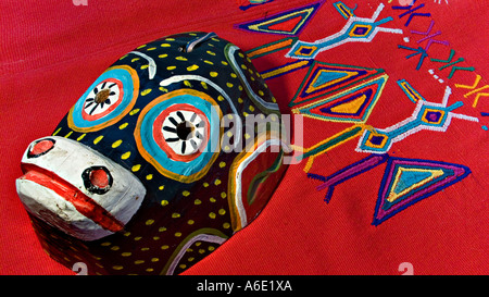 Masque de danse en bois guatémaltèque d'un singe à l'encontre d'un textile Maya en brocart rouge de Chajul hautes terres guatémaltèques Banque D'Images