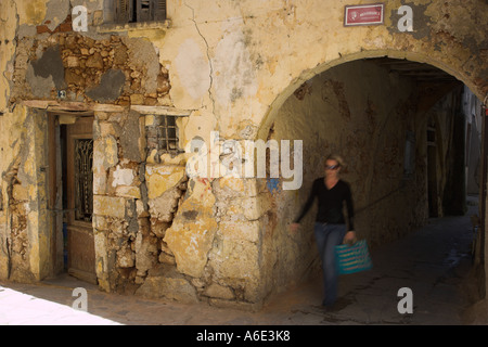 Grèce Crète de l'Ouest une jeune femme en passant devant une ancienne maison vénitienne dans la vieille ville de Chania Banque D'Images