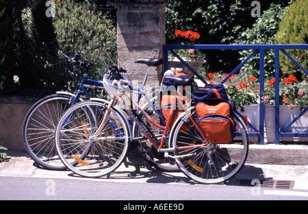 Vélos conçus pour une femme équipée de sacs de tourisme garés devant une auberge de jeunesse par une journée ensoleillée au Bugue Nouvelle-Aquitaine Dordogne France Banque D'Images