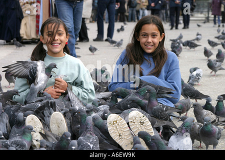 Deux jeunes filles bénéficiant de l'alimentation, les pigeons de la Place Saint Marc, Venise Banque D'Images