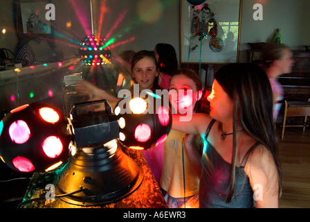 Excité les filles de neuf ans à une fête d'anniversaire avec des lumières disco Banque D'Images