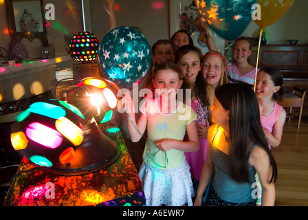 Excité les filles de neuf ans à une fête d'anniversaire avec des lumières disco Banque D'Images