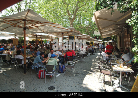 En été, les Français sont à l'ombre de la ville historique de Carcassonne, assis à l'extérieur, aux tables du bar en bord de trottoir, pour déguster des repas et des rafraîchissements en plein air français Banque D'Images