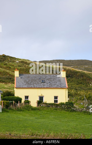 Petit gîte rural traditionnel peint en jaune sur l'anneau de Beara, itinéraire touristique près de l'extrémité ouest de la péninsule de Beara. Lackacroghan dans le comté de Cork en Irlande Banque D'Images