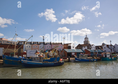 Carrossage ville docks avec poissons bateaux de pêche colorés dans l'eau et le développement du logement moderne vieux Portsmouth Hampshire Angleterre Banque D'Images