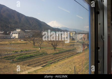 Le Japon Honshu central Mount Fuji Kawaguchiko paysage avec le mont Fuji enneigé dans bkgd Vue de derrière le train en marche de la fenêtre Banque D'Images