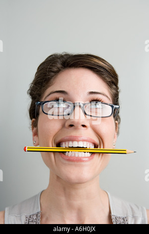 Femme avec un crayon dans la bouche Banque D'Images