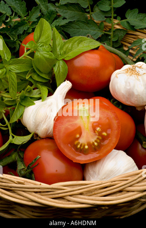 Panier avec des tomates fraîchement cueillies de l'ail et au basilic Banque D'Images