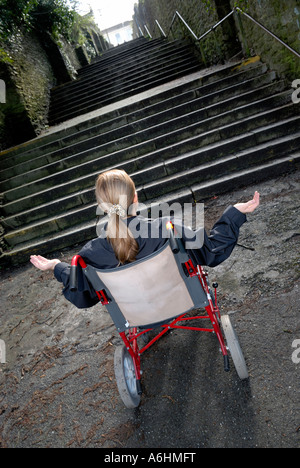 Mobilité woman in wheelchair incapable de monter un grand escalier Banque D'Images