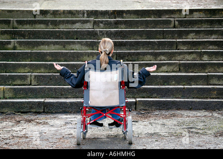 Mobilité woman in wheelchair incapable de monter un grand escalier Banque D'Images