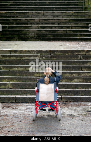 Mobilité woman in wheelchair incapable de monter un grand escalier Banque D'Images