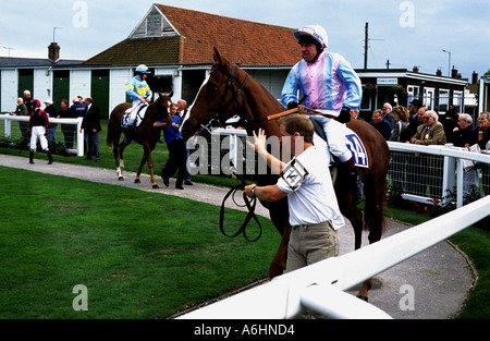 Coureurs et cyclistes dans l'anneau de parade de Great Yarmouth Norfolk race course Banque D'Images