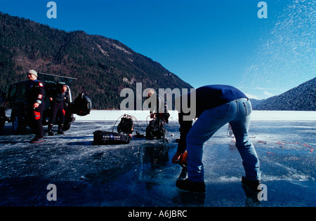 Ice diver de découper un trou dans la glace Banque D'Images