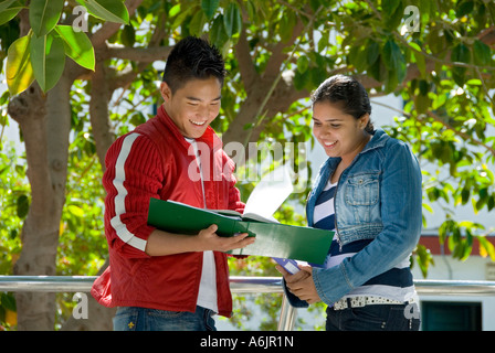 Les étudiants en plein air étudient l'Asie orientale détendue deux étudiants souriants d'âge adolescent comparent des notes d'étude à l'extérieur dans le jardin scolaire terrain de jeu Banque D'Images