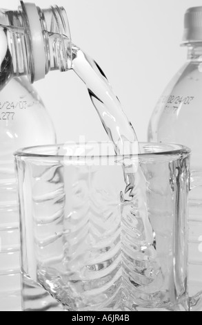 Eau embouteillée versée dans un verre à boire transparent, USA. Banque D'Images