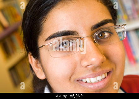 Asian teenage girl smiling uniforme proche attrayant étudiant confiant portant des lunettes dans bibliothèque de l'école Banque D'Images