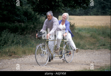 Mature couple riding en tandem via campagne anglaise Banque D'Images